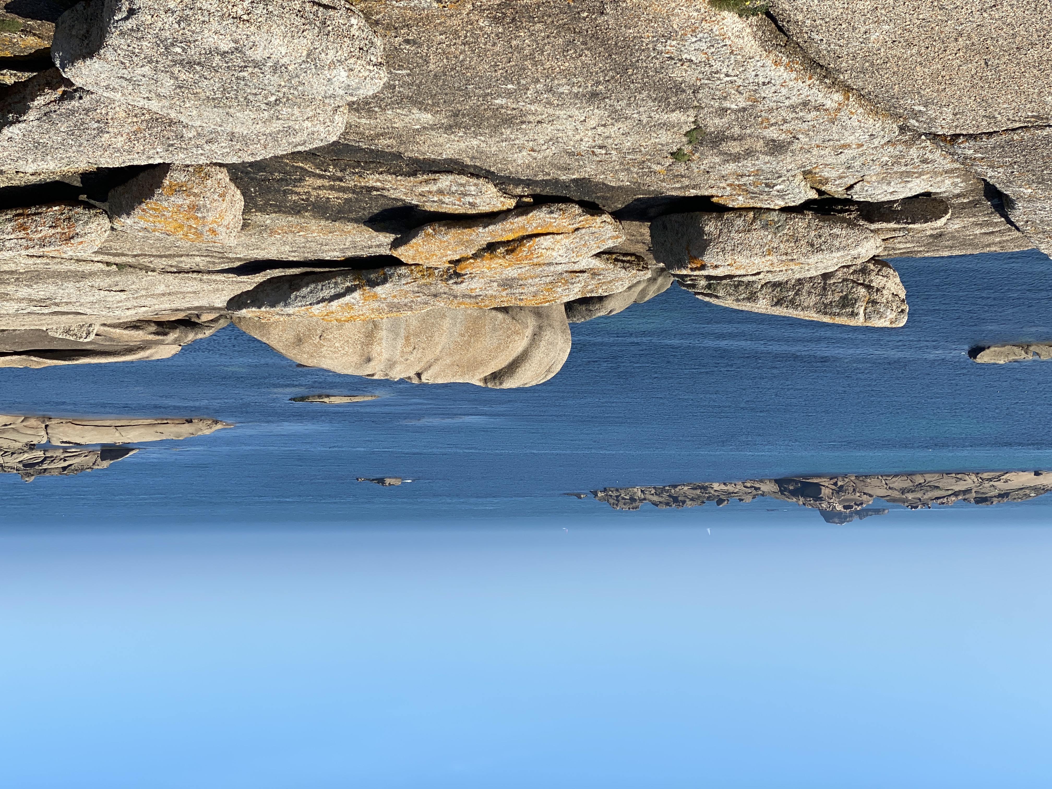 Granitfelsen spiegeln sich im stillen Gezeitentümpel