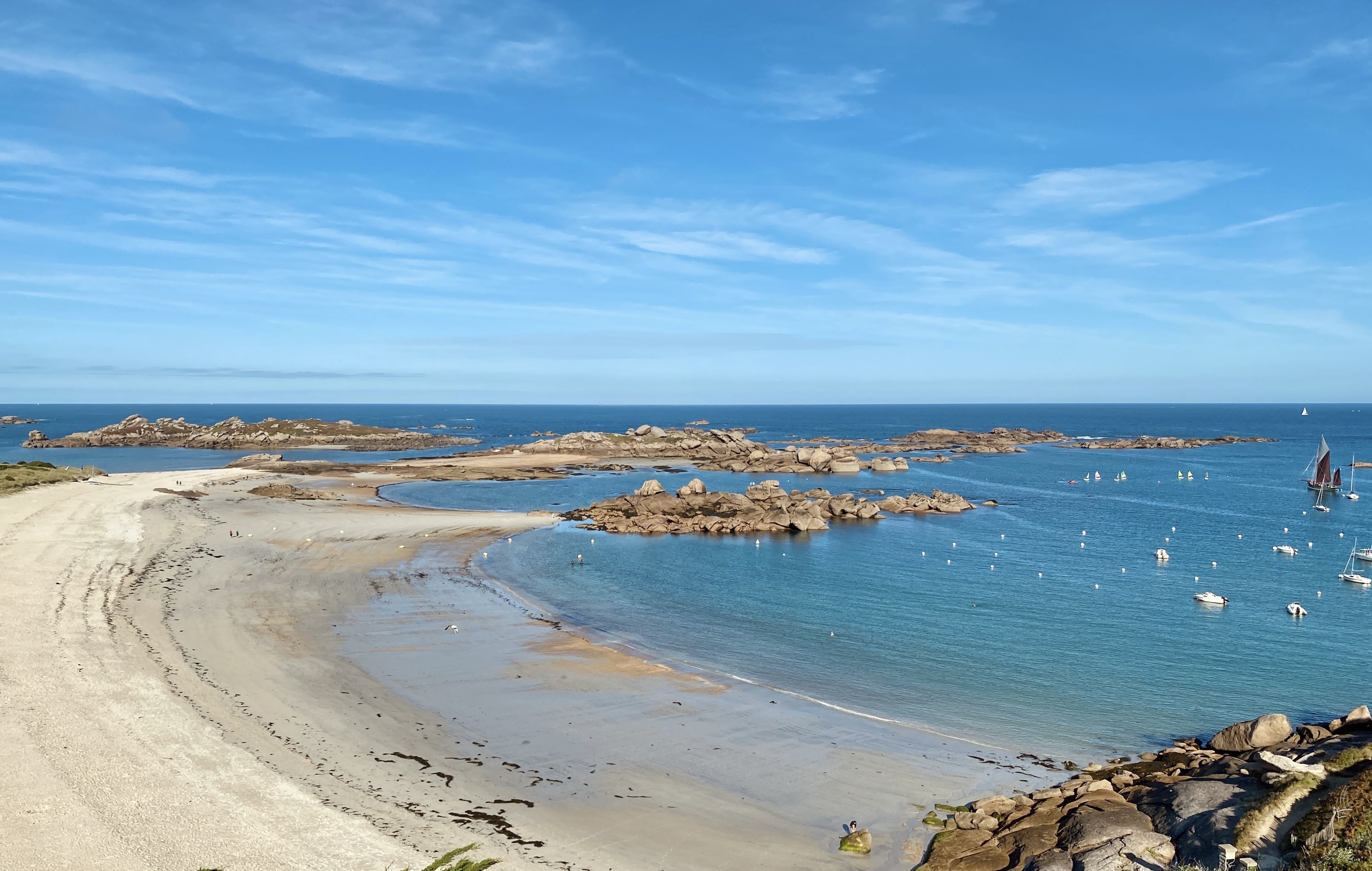 Panorama: weiter Strand bei Ebbe, Granitfelsen, Segelboote im Hintergrund